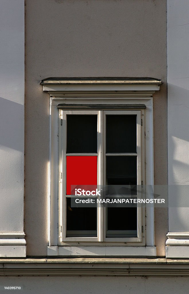 RED SIGHT WINDOW IN THE OLD HOUSE IN LJUBLJANA WITH ONE RED GLAS - SUITABLE FOR BOOK COVER Architectural Column Stock Photo