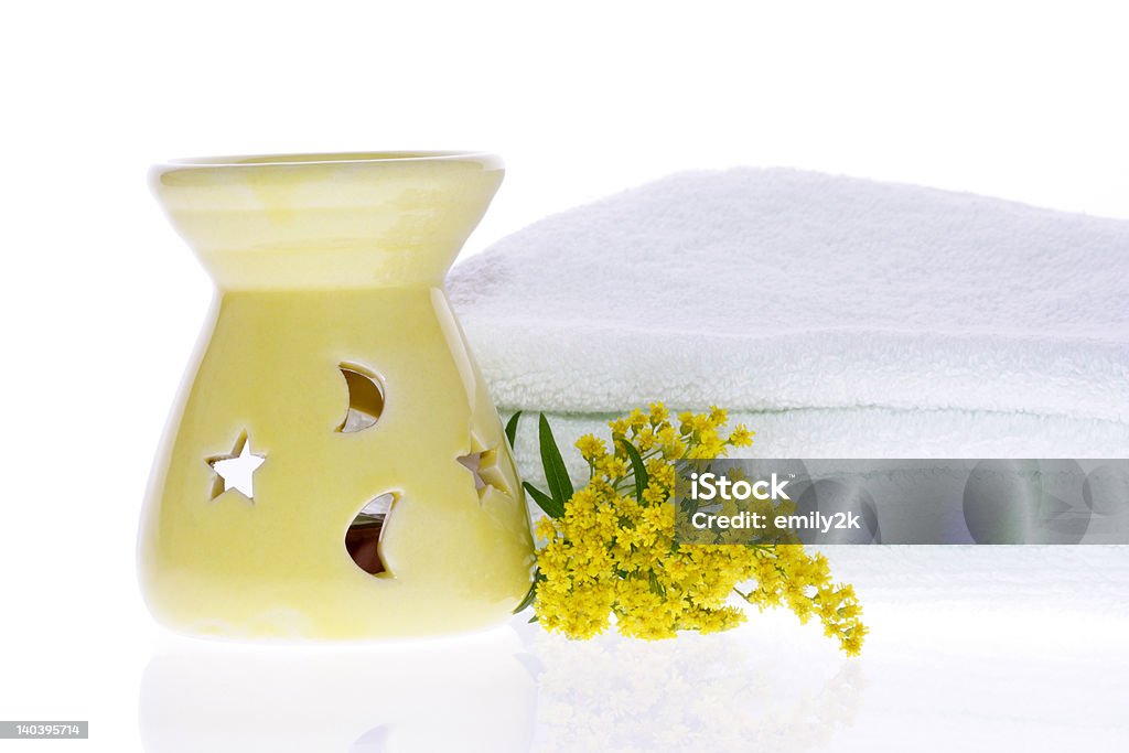 Oil Burner, Yellow Flower and White Towel Oil Burner, Yellow Flower and White Towel on White Background Alternative Therapy Stock Photo
