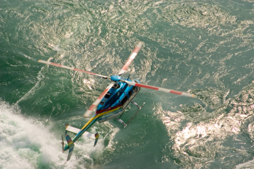 Helicopter flying over a fast river.