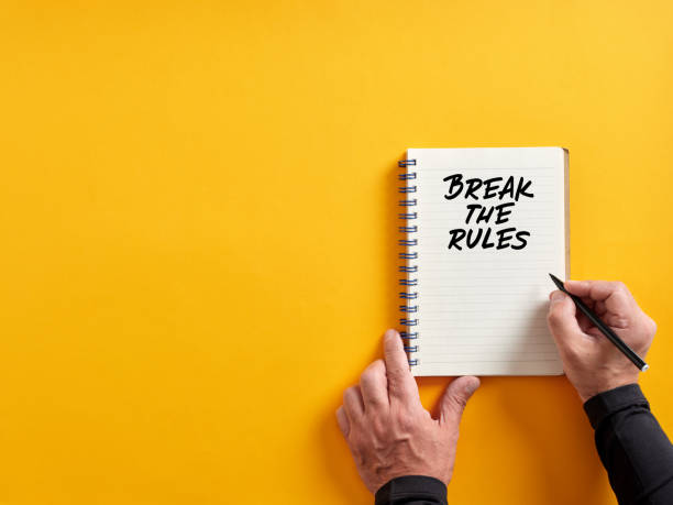 istock Male hand writing break the rules on a notepad. Exclusion from rules, policies or regulations 1403957969