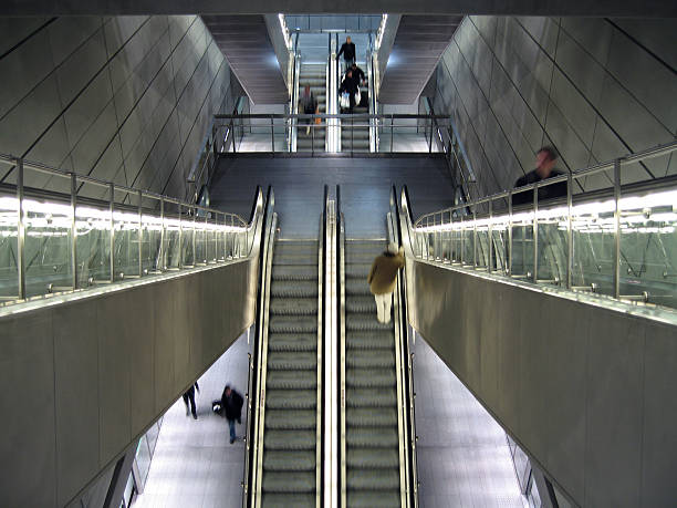 Metal and men Escalators and commuters in a Copenhagen metro station, blurred motion. alintal stock pictures, royalty-free photos & images