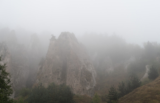 Fog view on the Khndzoresk ancient cave city in the mountain rocks. Armenia landscape attraction. Abandoned ruins in the mist. Atmospheric stock photo.