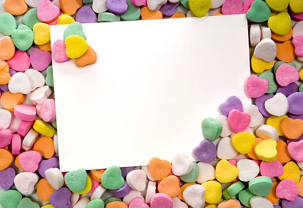 Close-up of blank white notecard surrounded by candy hearts