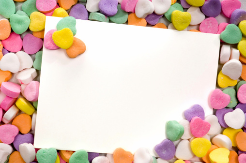 white notecard surrounded by candy conversation hearts- blank