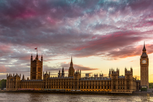 United Kingdom House of Parliament and the Big Ben tower under a dramatic fiery sky. Photo taken on 11th of June 2022 in London, United Kingdom.