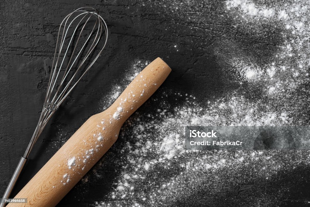 Scattered flour with rolling pin on black background Scattered flour with rolling pin on black background top view Baking Stock Photo