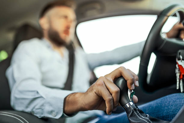 empresário dirigindo para o trabalho usando vara de câmbio - car driving men reversing - fotografias e filmes do acervo