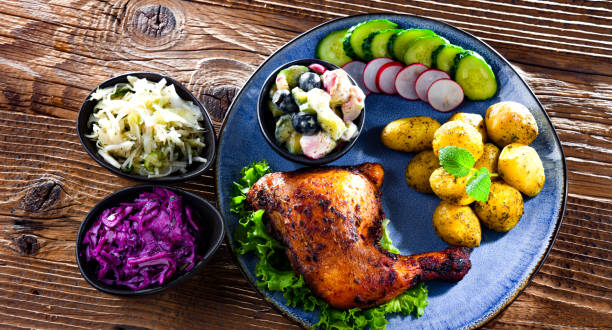 istock Baked chicken leg with potatoes and vegetable salads 1403968453