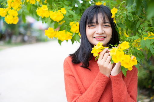 Portrait young girl with yellow flowers, Asian girl.