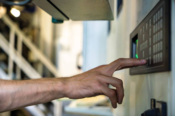 istock close up engineer hand finger press button controling cnc machine, Workers operating factory machinery in warehouse 1403969173