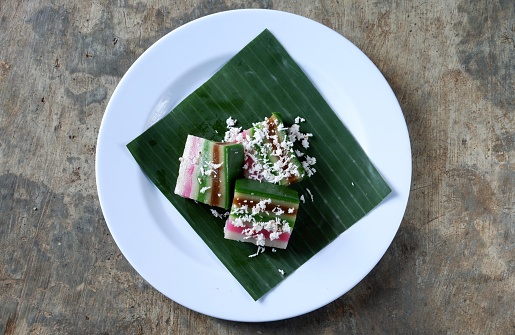 Layer cake and grated coconut on plate with banana leaf, malay food