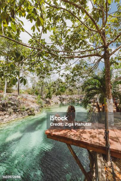 Woman Sitting On A Dock In Cenote Stock Photo - Download Image Now - Cancun, Mexico, Cenote