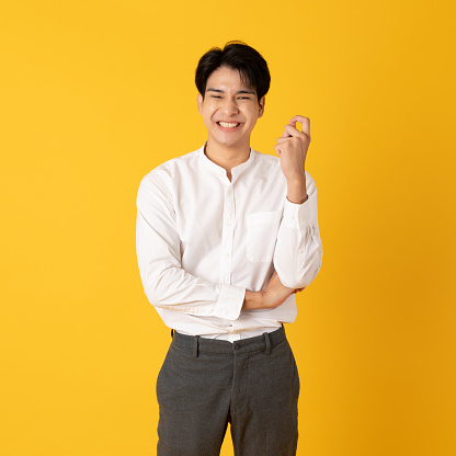 Good looking teenage asian man with laugh isolate on yellow background