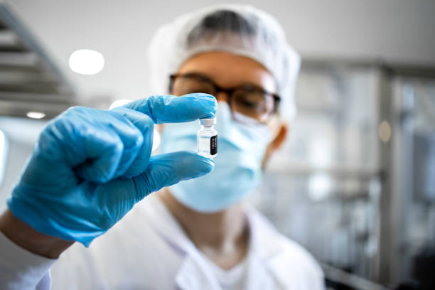 trabajador farmacéutico o tecnólogo en equipos de protección que controlan la calidad de la producción de vacunas en la fábrica. - medicamento fotografías e imágenes de stock