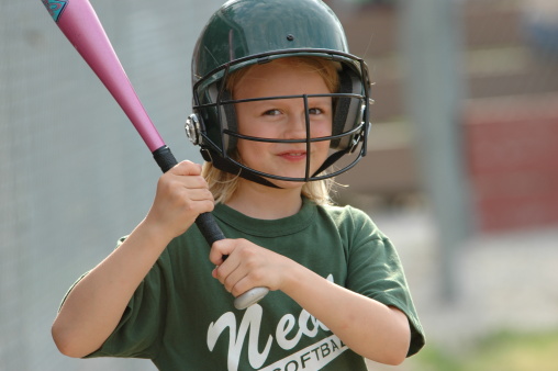 Young softball girl smiling on deck awaiting her turn at bat
