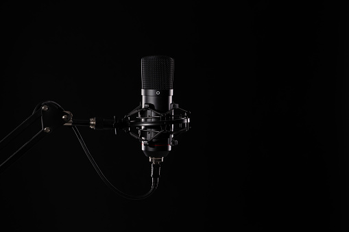 Proffesional studio microphone, isolated on the black background. Podcasts and music recording.