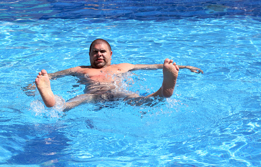 fun overweight man bathing in pool