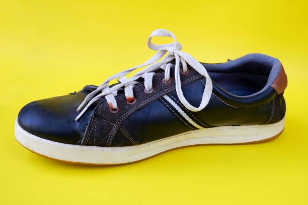 istock Black shoes isolated on yellow background 1403979709