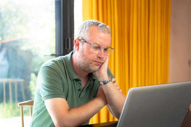 istock Worried man looking at laptop in modern home interior 1403984415