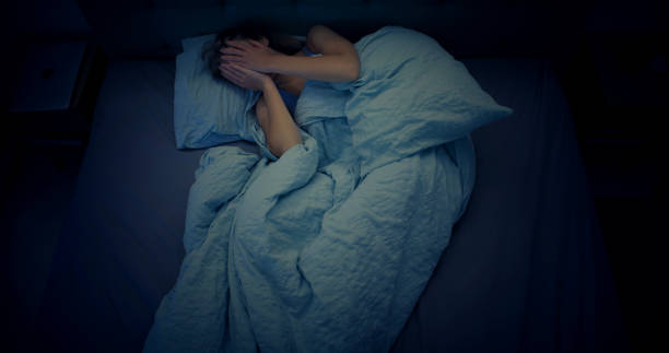 woman in bed can't sleep due to insomnia - insomnia imagens e fotografias de stock