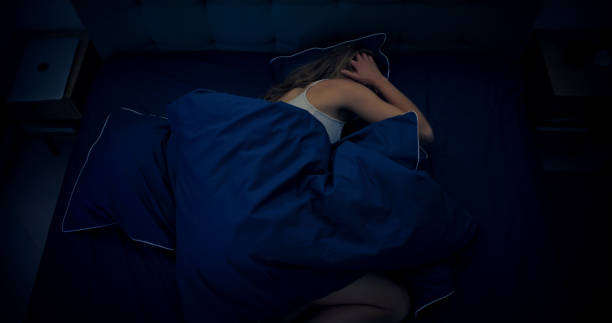 istock Woman in bed can't sleep due to insomnia 1403985888