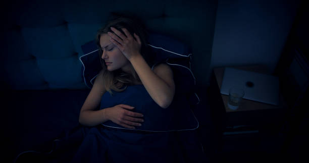 Woman in bed can't sleep due to insomnia stock photo