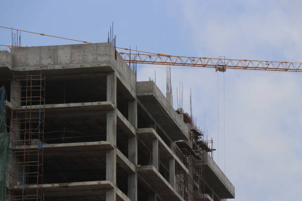 istock Construction of the new building with Cranes on the constructing site. Crane and building construction site against the sky 1403987562