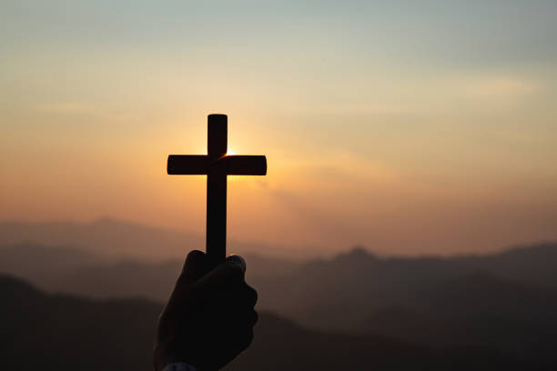 istock silhouette hand holding cross 1403989778