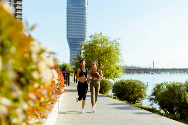istock Young woman taking running exercise by the river promenade 1403990860