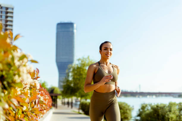 istock Young woman taking running exercise by the river promenade 1403991018
