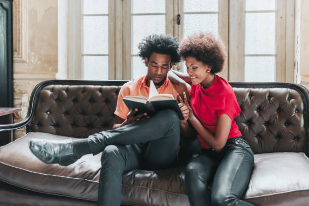 istock young black couple reading book together on sofa 1403991264