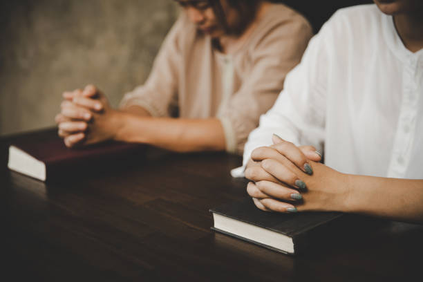 istock Two women praying worship believe 1403991296