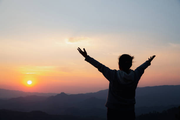 frauenverehrung bei sonnenuntergang - god freedom arms raised high angle view stock-fotos und bilder