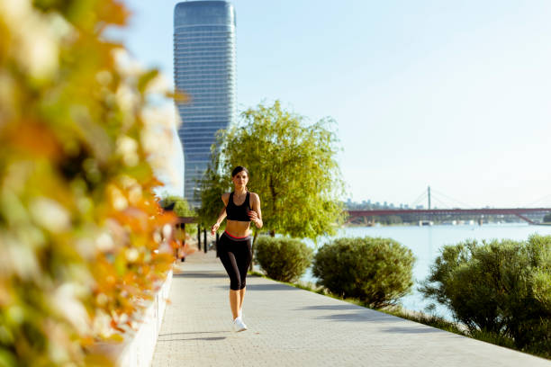 istock Young woman taking running exercise by the river promenade 1403991518