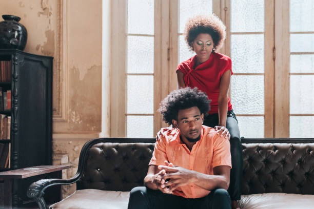 istock serious young black couple sitting together on sofa 1403991857