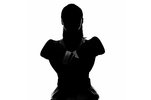 Silhouette of woman walking in sports hall during practice.
