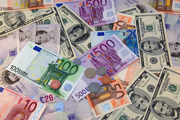 A pile of several different currencies from around the world stock photo