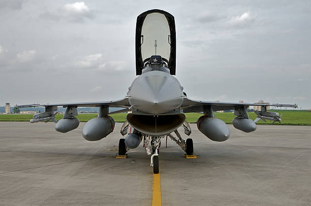 Fighter jet (head-on view) US fighter jet parked on the tarmac. The canopy is up, the sky is overcast. jet intake stock pictures, royalty-free photos & images