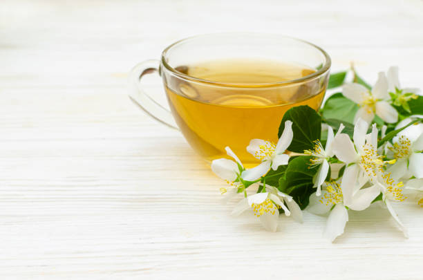 Jasmine tea and jasmine flowers on wooden background