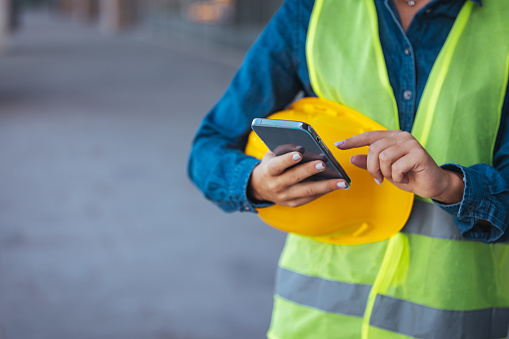 Construction worker hands using smartphone