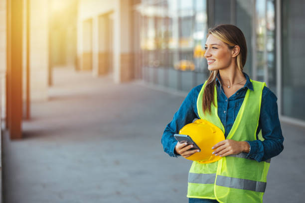 contremaîtresse envoyant des instructions via smartphone. - building contractor flash photos et images de collection