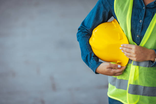istock Technician woman standing with yellow safety helmet 1403995427