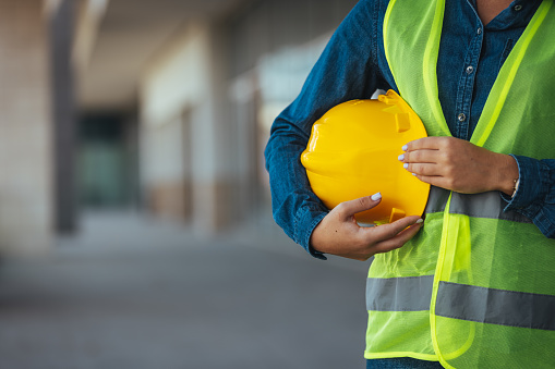 Construction worker holding yellow hemlet