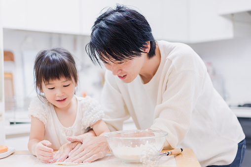 Dad kneading dough with his daughter
