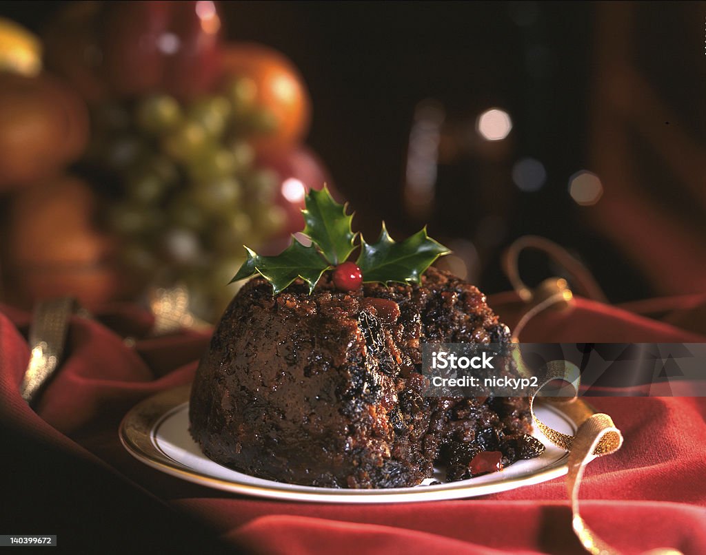 Christmas pudding Christmas Pudding decorated with holly leaves  on red background Christmas Pudding Stock Photo