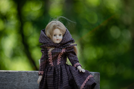 Amazing realistic vintage porcelain doll, toy with brown eyes, selective focus