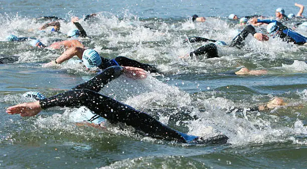 Swimmers churning up the water at a local triathlon.