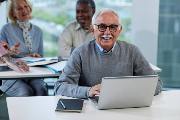 istock A senior man is smiling while having a retraining class with a multicultural group of senior people in the classroom. 1403999579