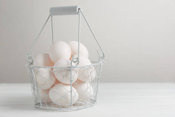 chicken eggs in a white decorative basket on a white background