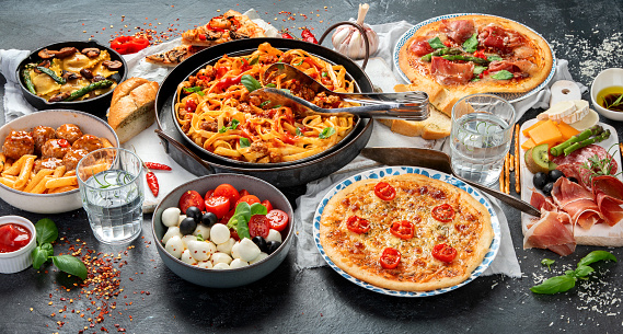 Italian food assortment on dark background. Traditional food concept. Dishes and appetizers of indeed cuisine.